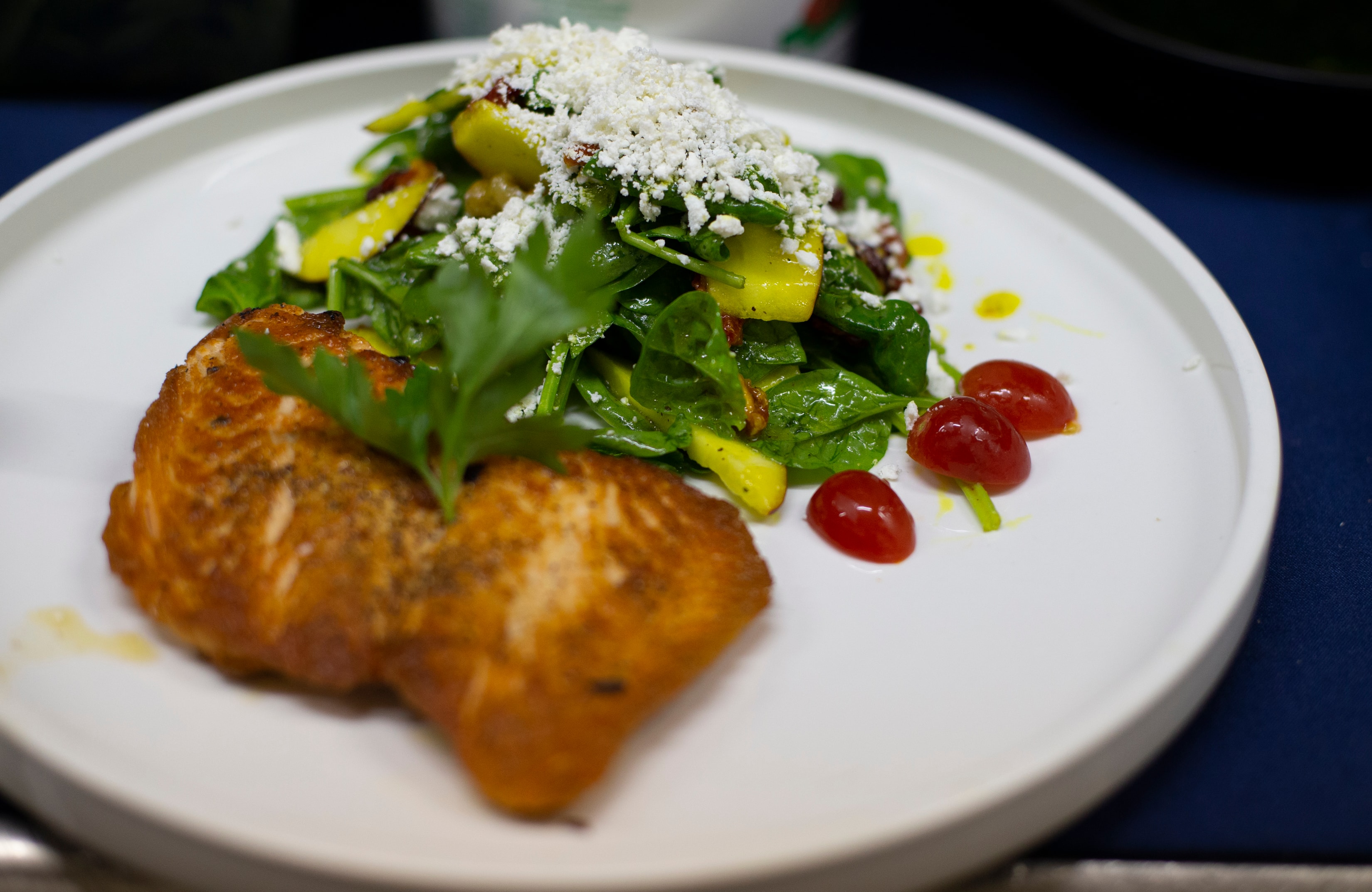 Seared salmon with arugula, mango and goat cheese salad