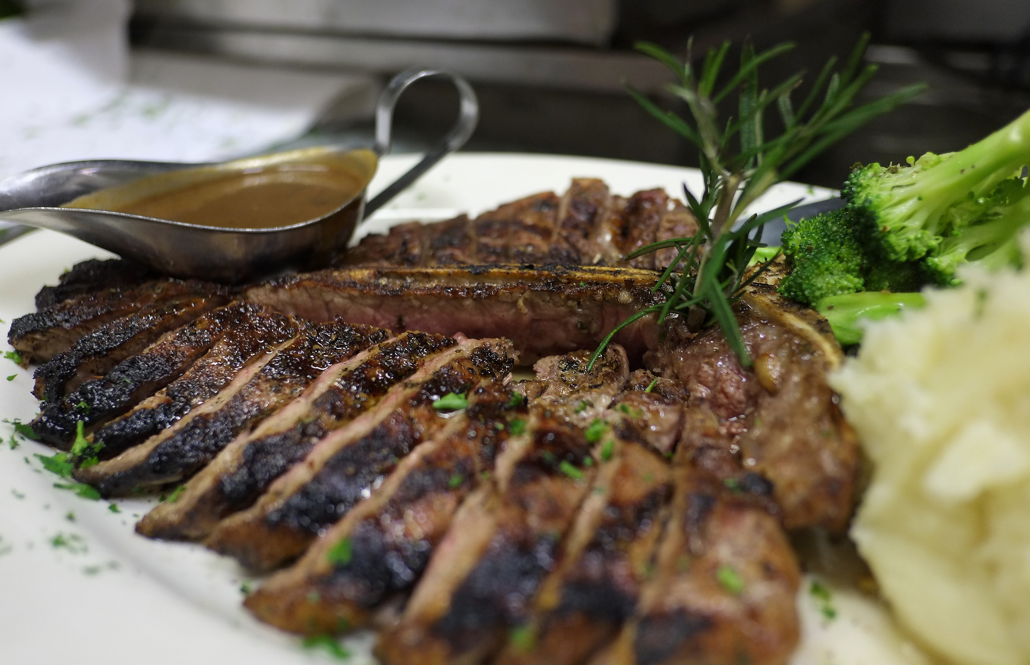 Sliced grilled steak with broccoli and mashed potatoes